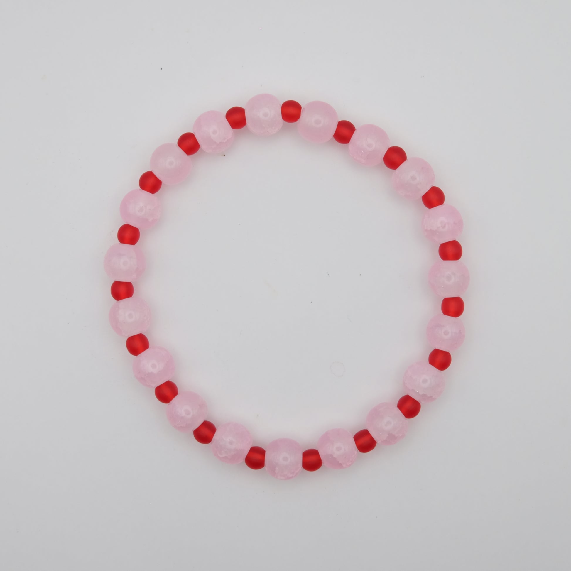Beaded bracelet with pink and red beads on a white background