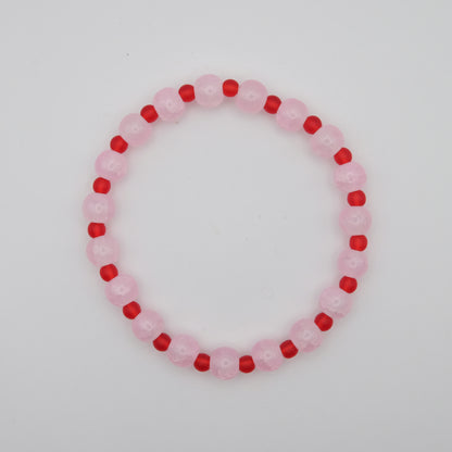 Beaded bracelet with pink and red beads on a white background