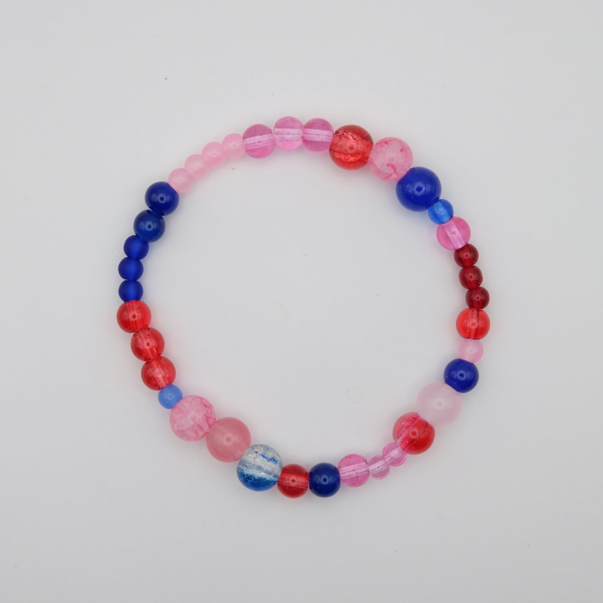 Pink, red and blue glass beaded bracelet on a white background.