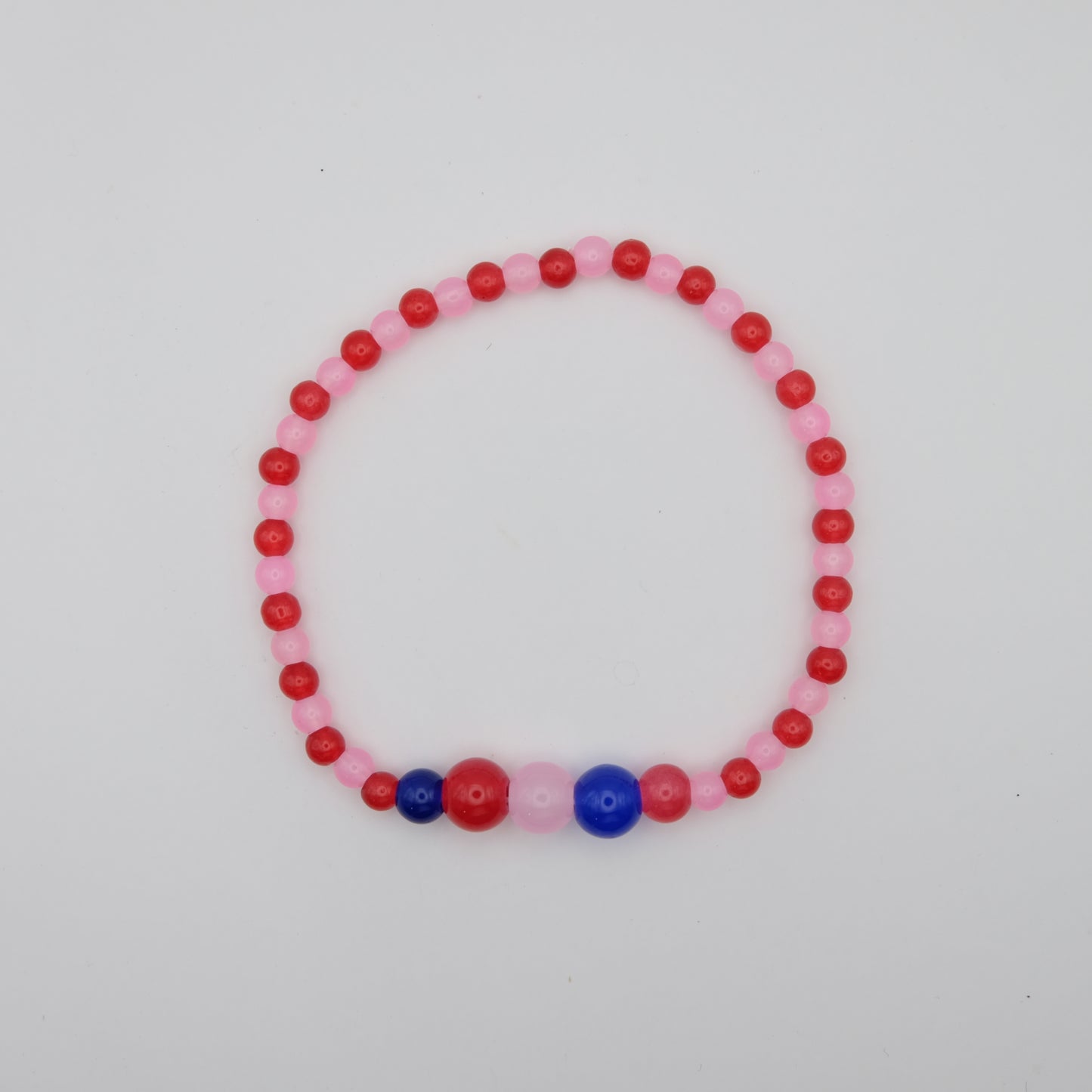 Beaded bracelet with pink, red, and blue beads on a light gray background