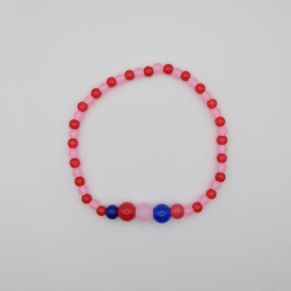 Beaded bracelet with pink, red, and blue beads on a light gray background
