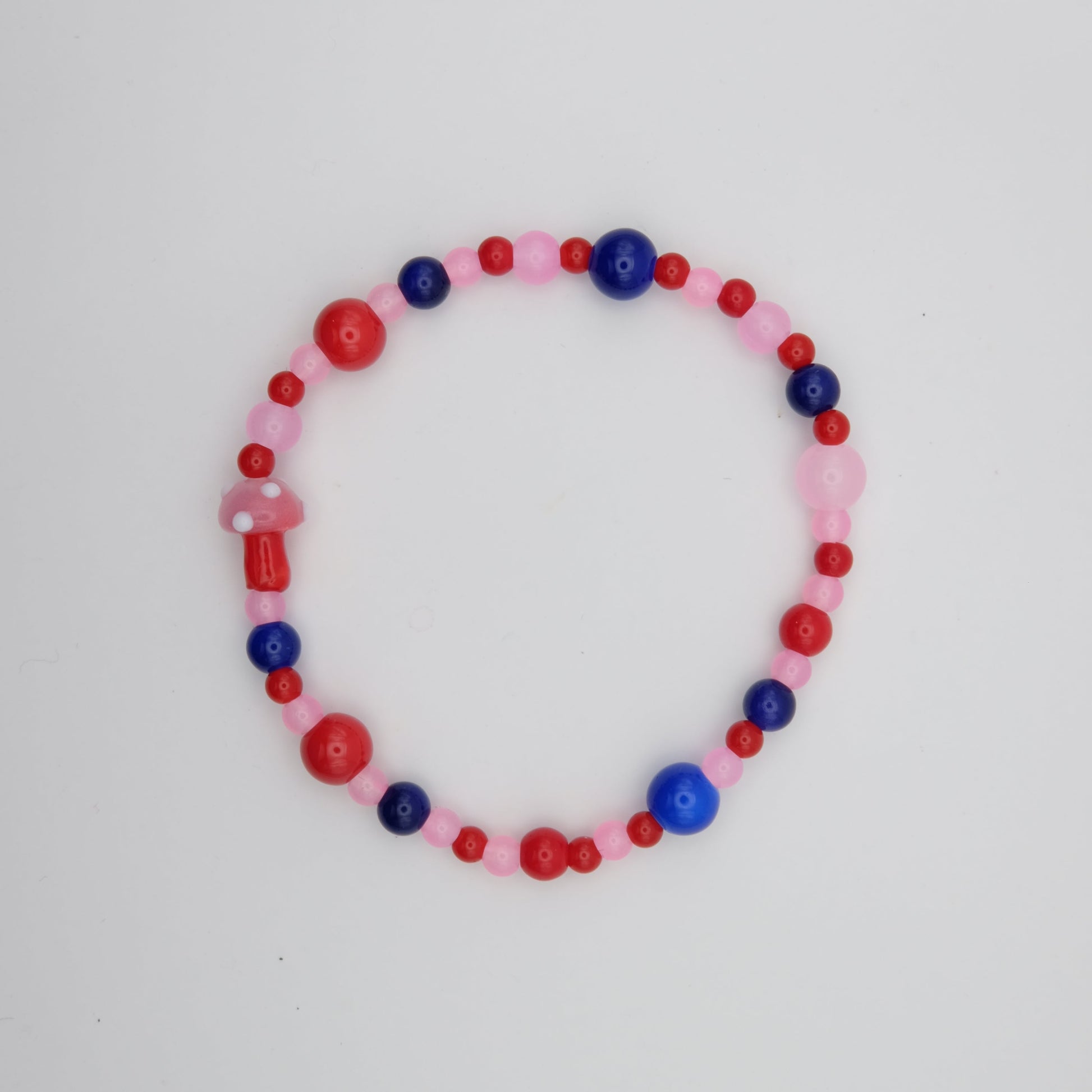 Beaded bracelet with pink, red, and blue beads on a white background