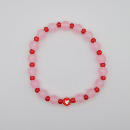 Beaded bracelet with pink and red beads on a white background