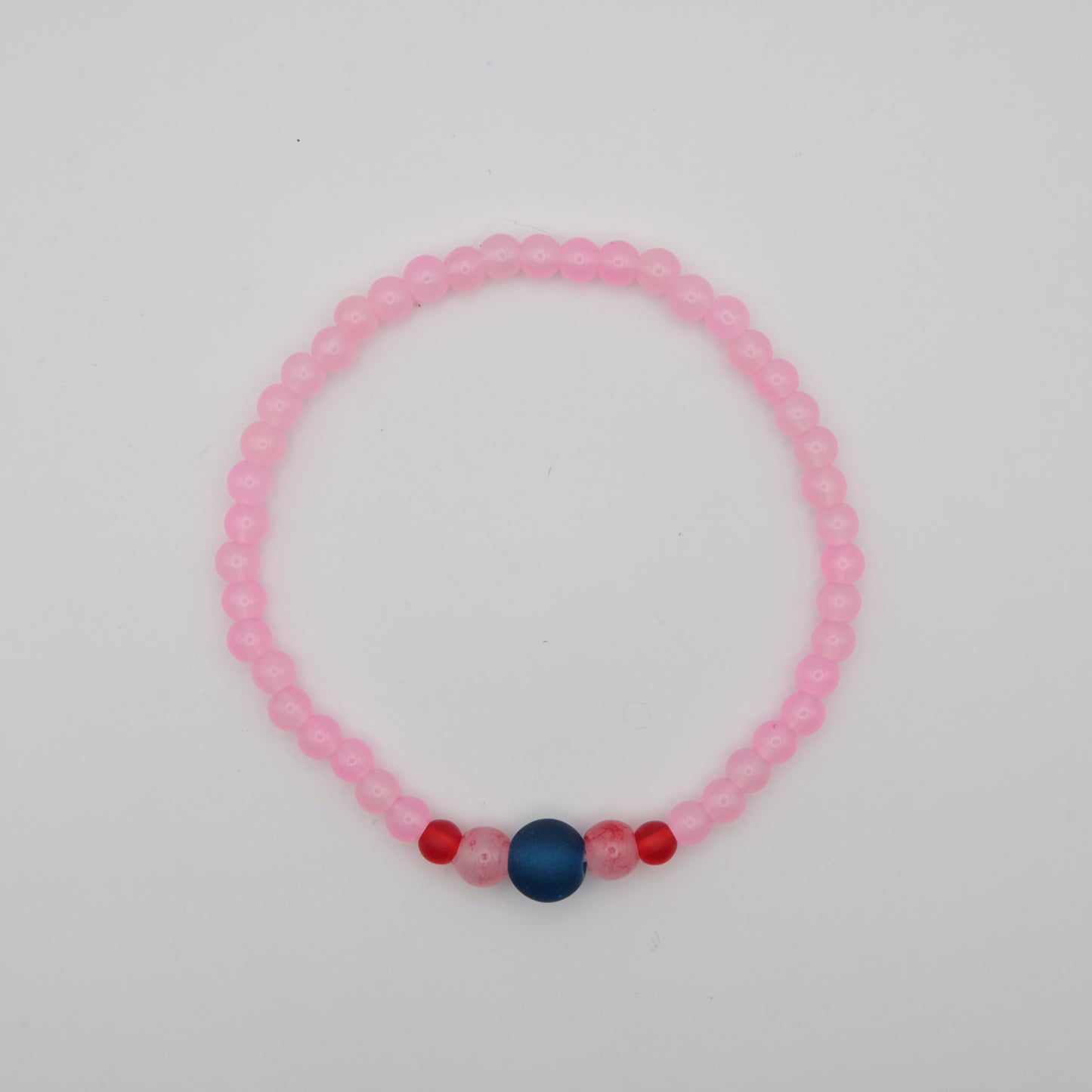 Pink beaded bracelet with blue and red beads on a white background