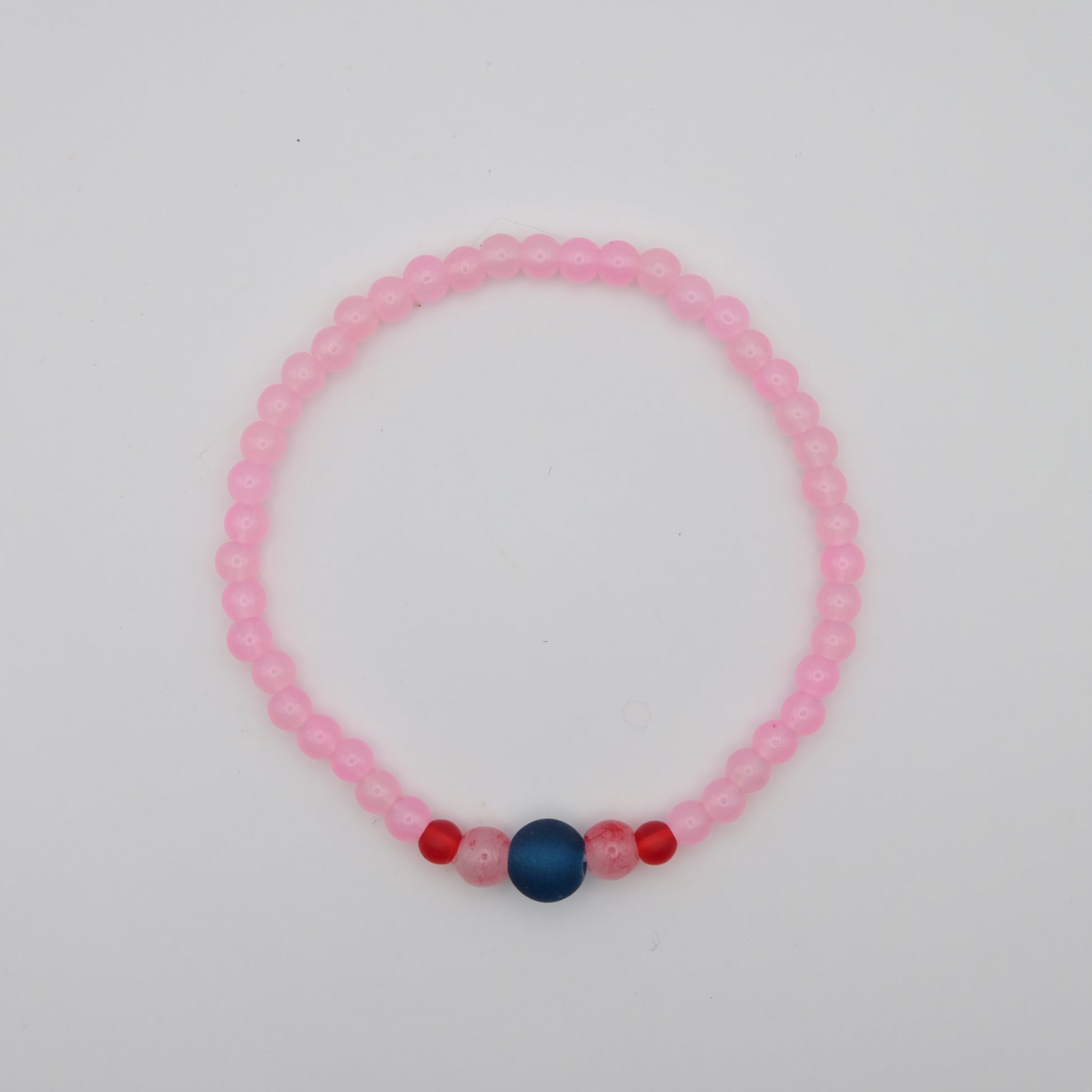 Pink beaded bracelet with blue and red beads on a white background