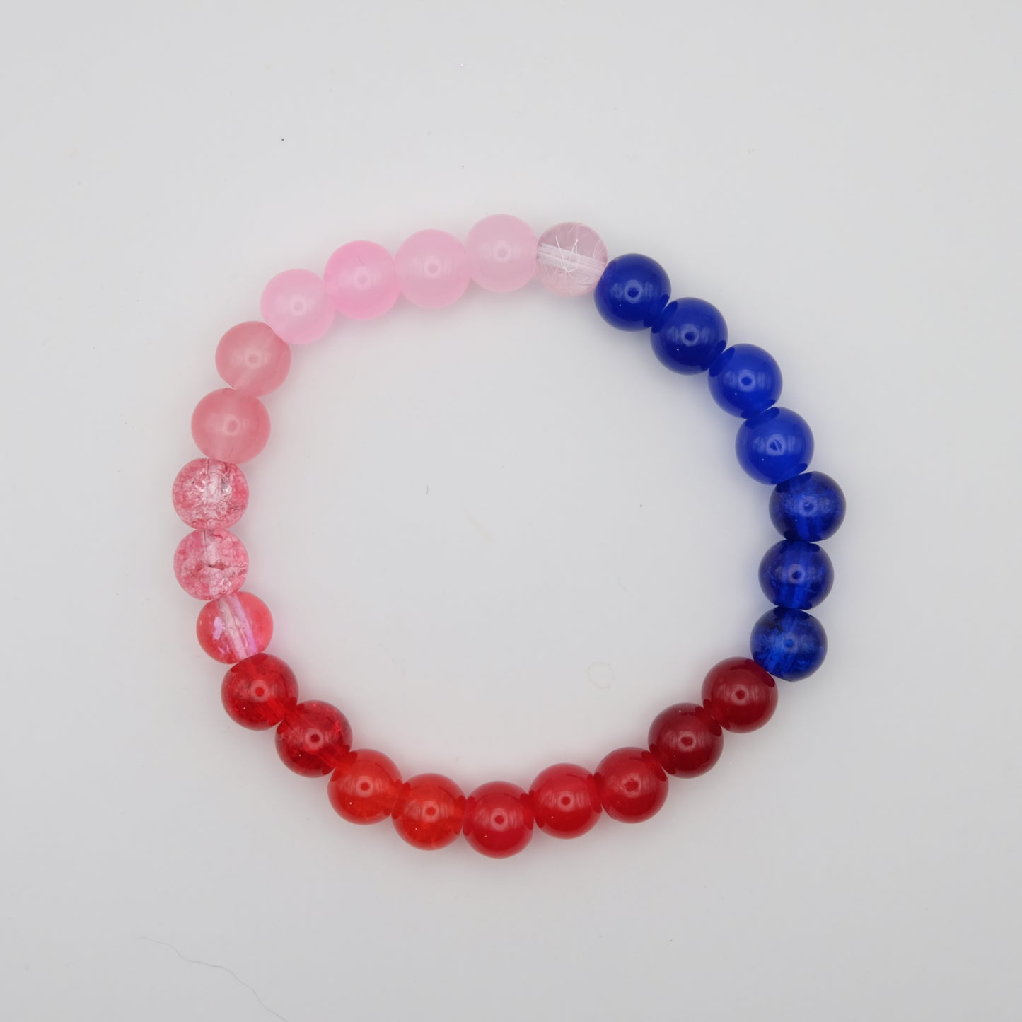 Beaded bracelet with pink, red, and blue beads on a white background