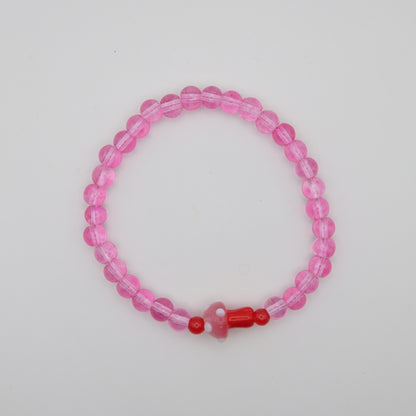 Pink beaded bracelet with a red accent on a plain background