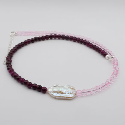 A handmade beaded necklace featuring 4mm light pink glass beads on one side, 4mm deep purple glass beads on the other, and a white baroque freshwater pearl centrepiece, displayed on a white background.