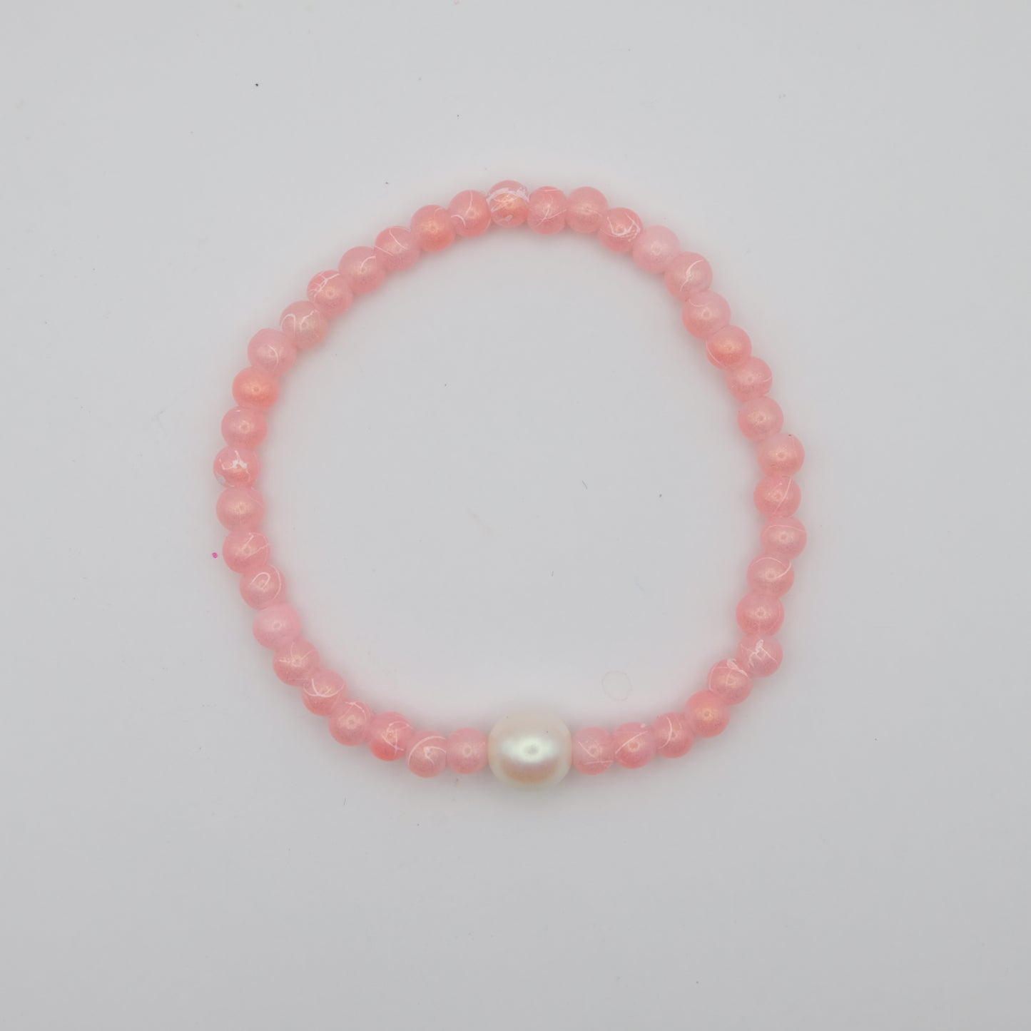 Pink beaded bracelet with a larger Czech glass pearl feature bead on a white background