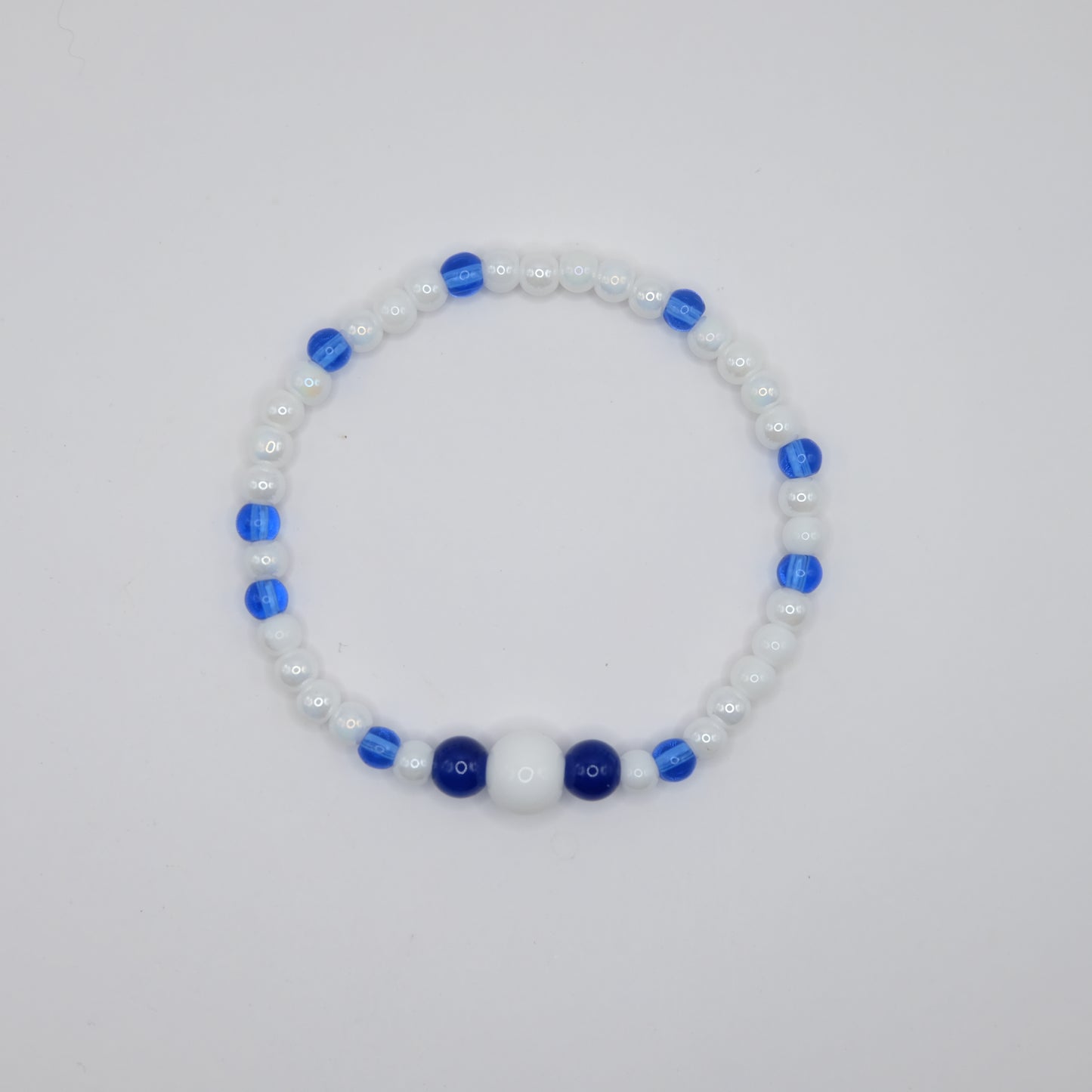 Beaded bracelet with blue and white beads on a light gray background