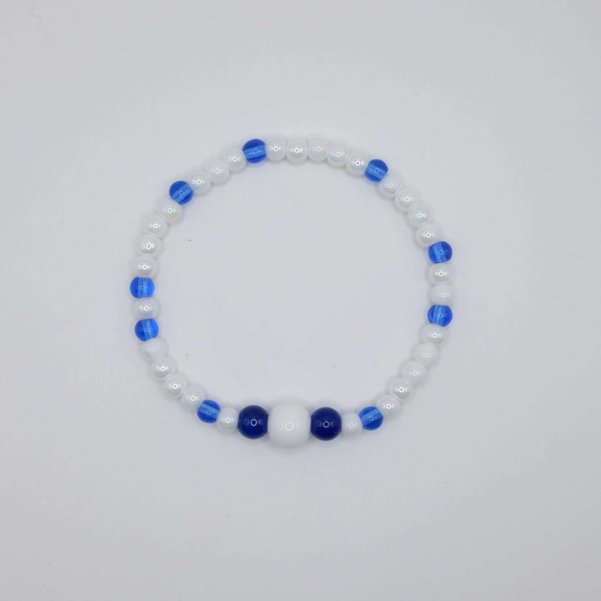 Beaded bracelet with blue and white beads on a light gray background