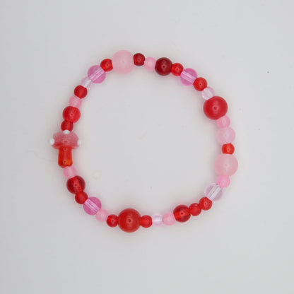 Beaded bracelet with pink and red beads on a light gray background