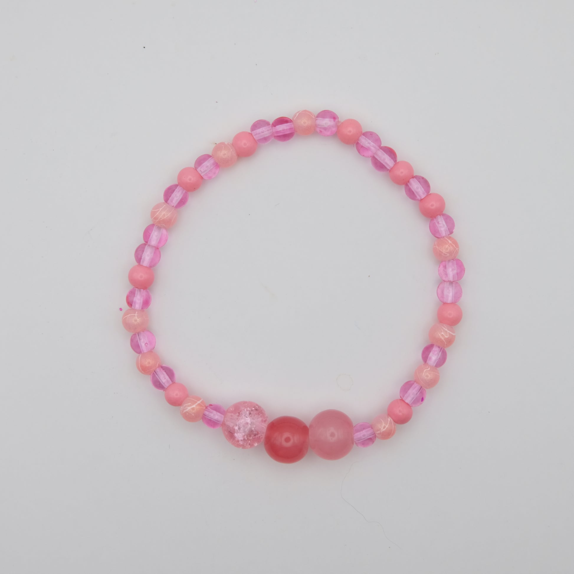Pink beaded bracelet on a light gray background