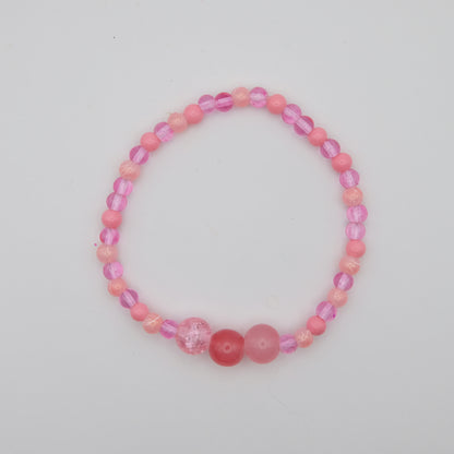 Pink beaded bracelet on a light gray background