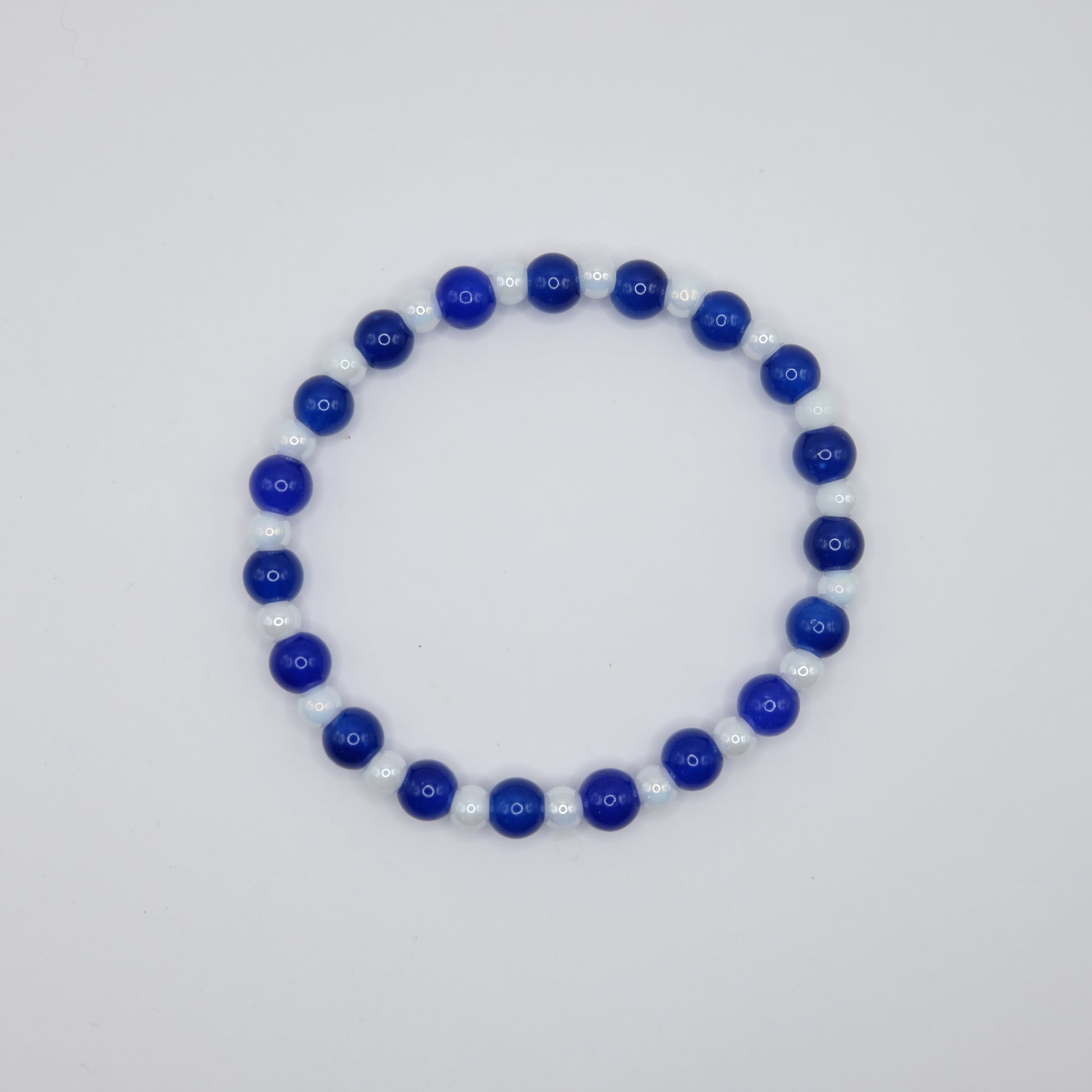 Beaded bracelet with blue and white beads on a light gray background