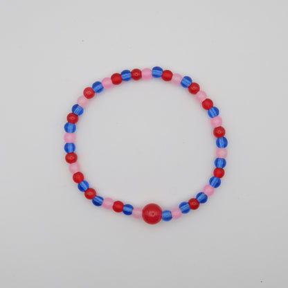 Beaded bracelet with red, blue, and pink beads on a light gray background