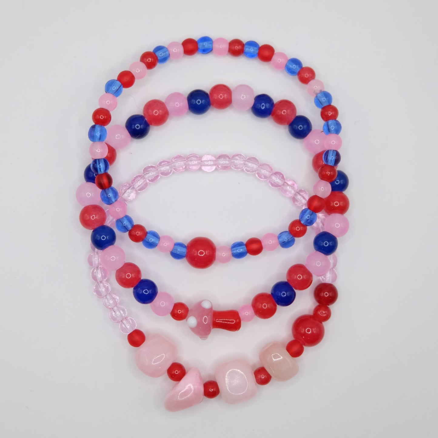 Set of 3 colorful beaded necklaces on a light gray background