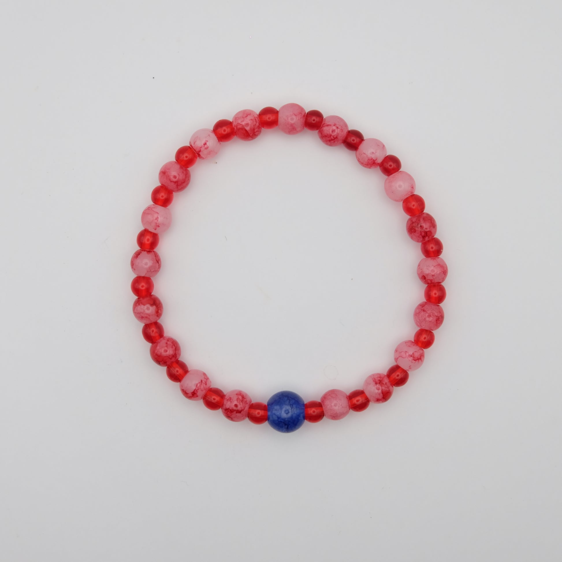 Beaded bracelet with red, pink, and blue beads on a white background