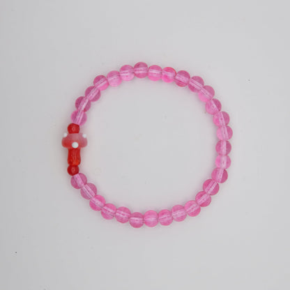 Pink beaded bracelet with a red accent on a white background