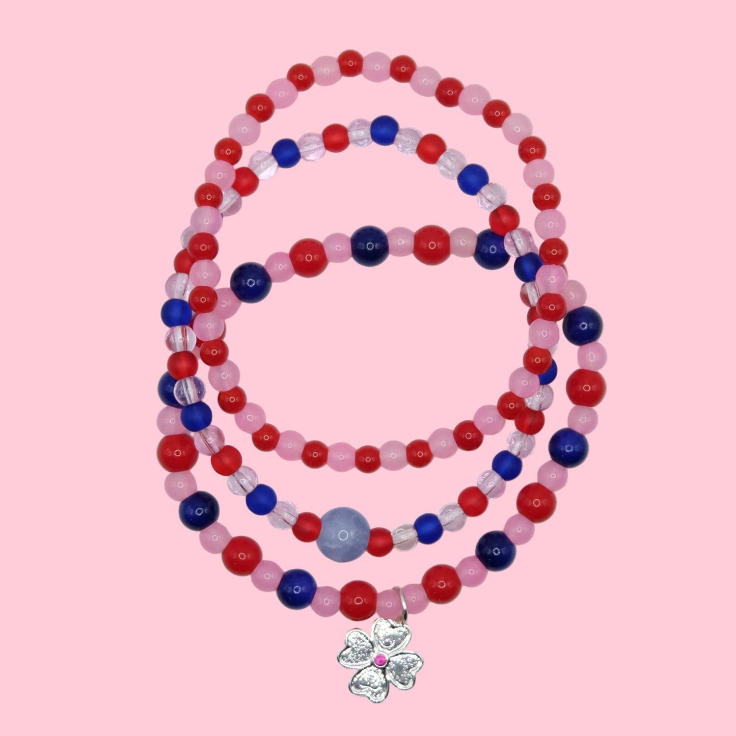 A one of a kind stack of three elastic beaded bracelets featuring colourful glass beads in pink, red and blue with mixed finishes.