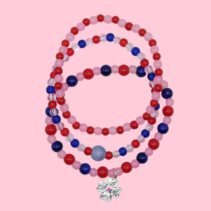 A one of a kind stack of three elastic beaded bracelets featuring colourful glass beads in pink, red and blue with mixed finishes.