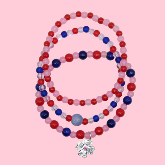 A one of a kind stack of three elastic beaded bracelets featuring colourful glass beads in pink, red and blue with mixed finishes.