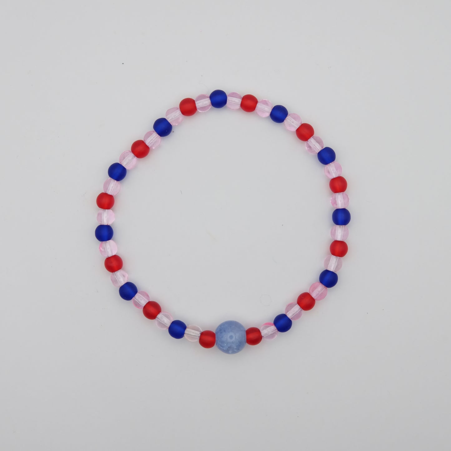 Beaded bracelet with red, blue, and pink beads on a white background
