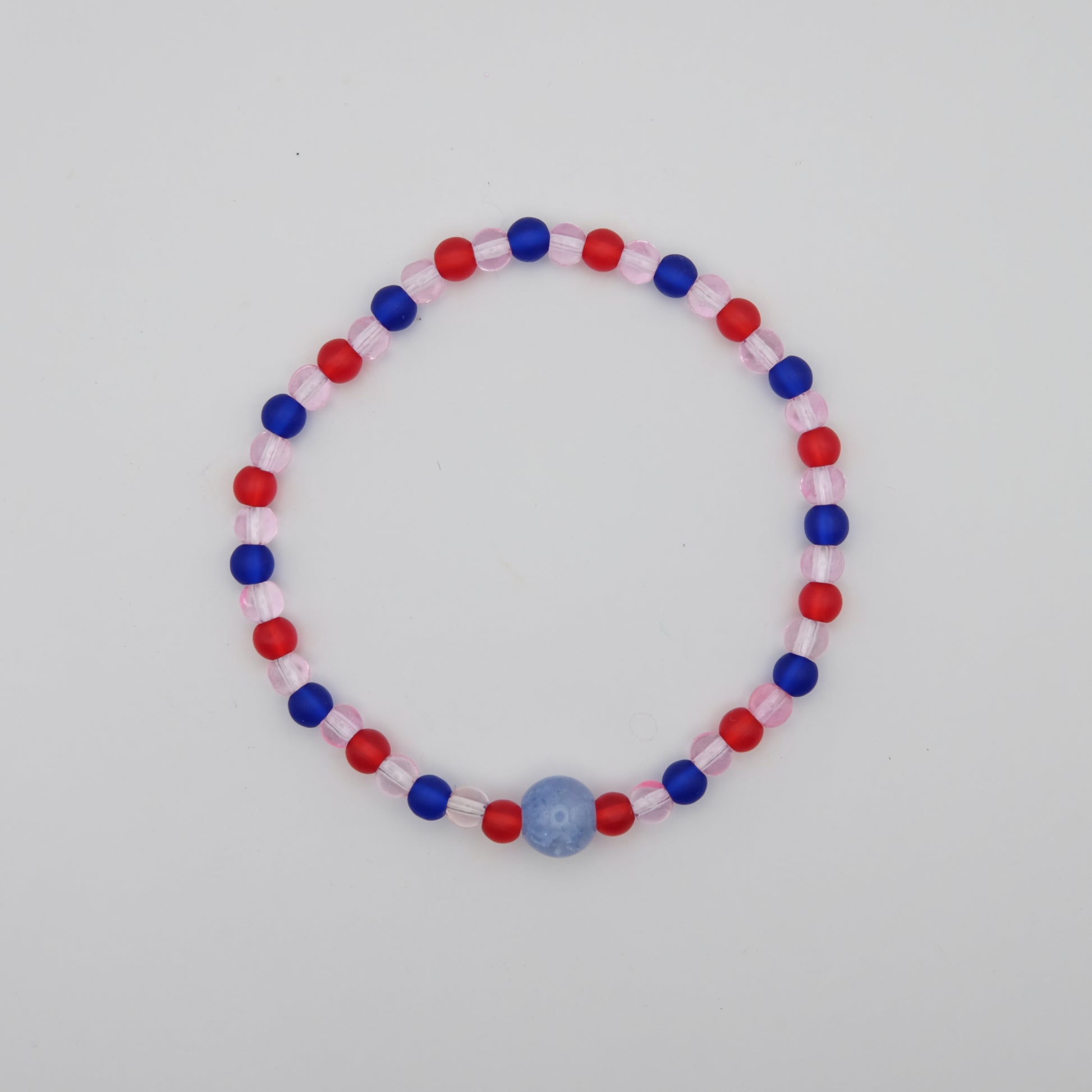 Beaded bracelet with red, blue, and pink beads on a white background