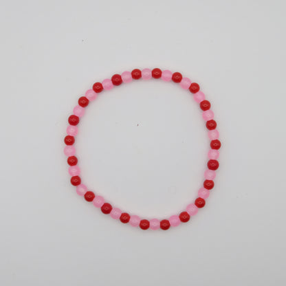 Beaded bracelet with pink and red beads on a white background
