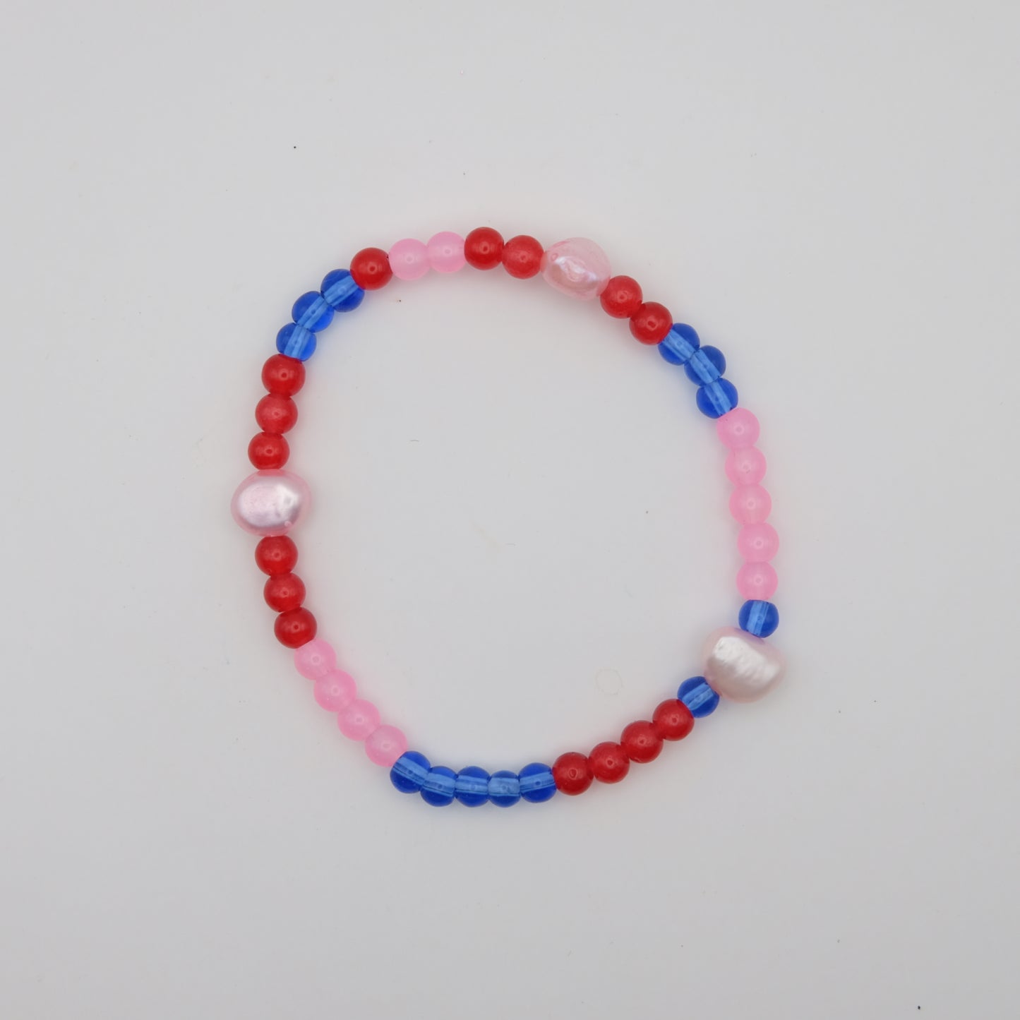 Beaded bracelet with red, blue, and pink beads on a white background