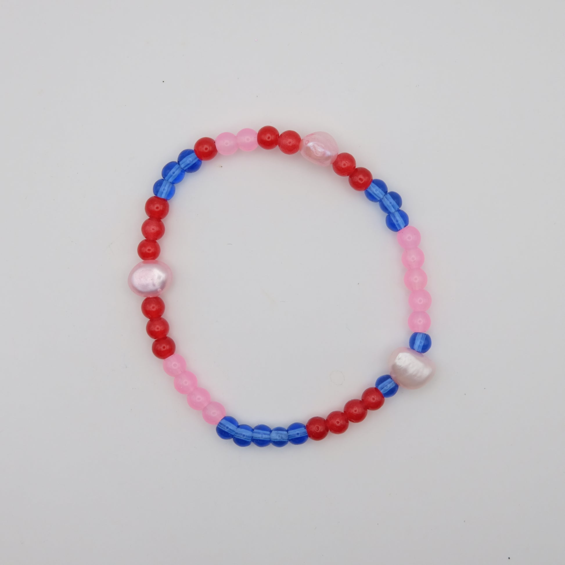 Beaded bracelet with red, blue, and pink beads on a white background