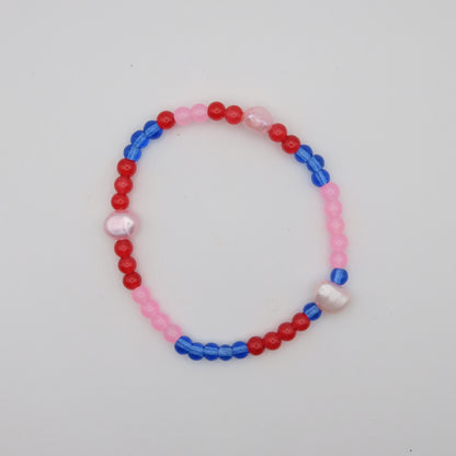 Beaded bracelet with red, blue, and pink beads on a white background