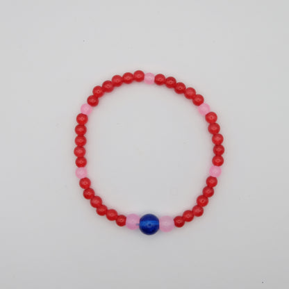 Beaded bracelet with red and pink beads on a white background
