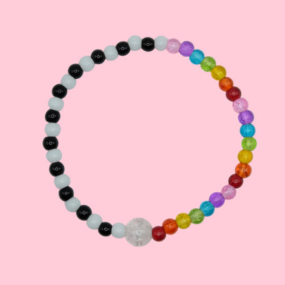 An elastic beaded bracelet composed of alternating black and white 4mm glass beads on one side and rainbow 4mm glass beads on the other, featuring a single clear crackle glass bead at the centre, shown on a white background.