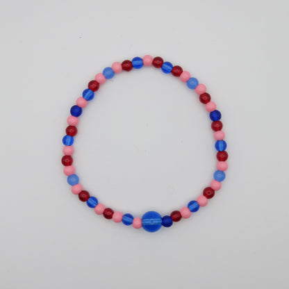 Beaded bracelet with red, blue, and pink beads on a light gray background