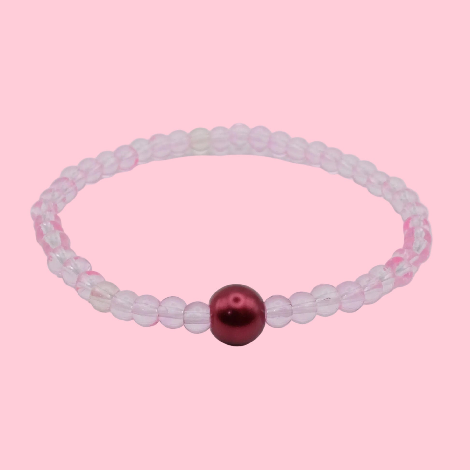 An elastic beaded bracelet composed of translucent light pink 4mm glass beads featuring a single wine-coloured glass pearl bead at the centre, shown on a white background.