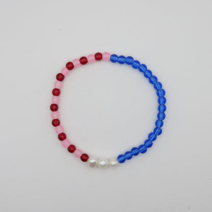 Beaded bracelet with red, pink, and blue beads on a white background