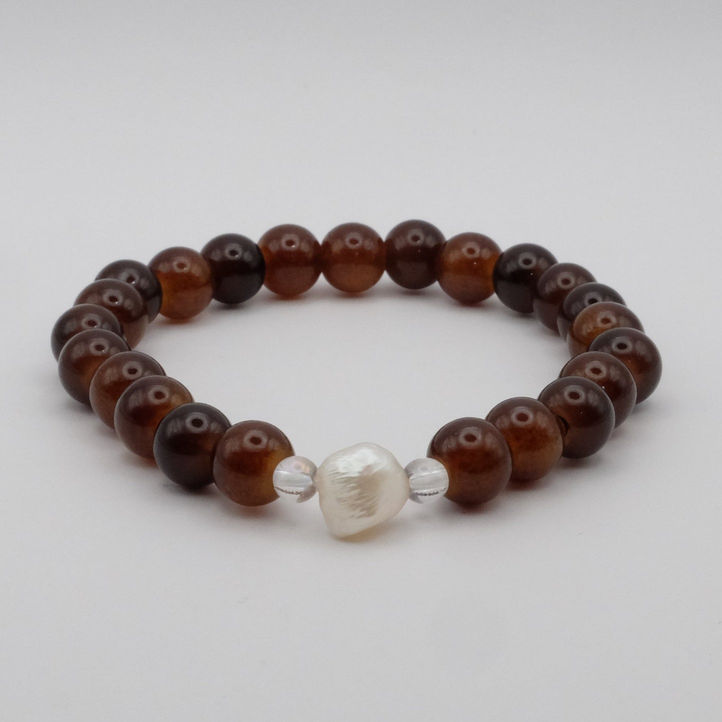 Beaded bracelet with brown and silver beads on a light gray background