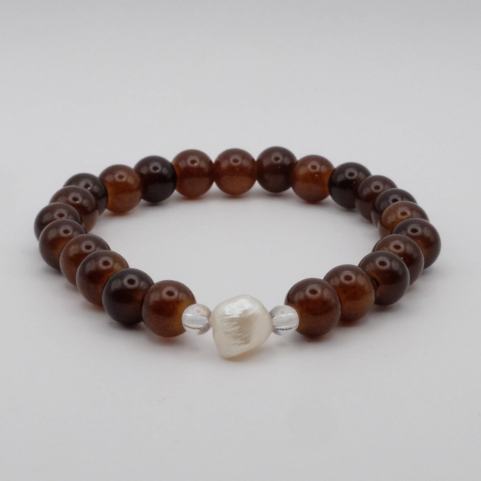 Beaded bracelet with brown and silver beads on a light gray background