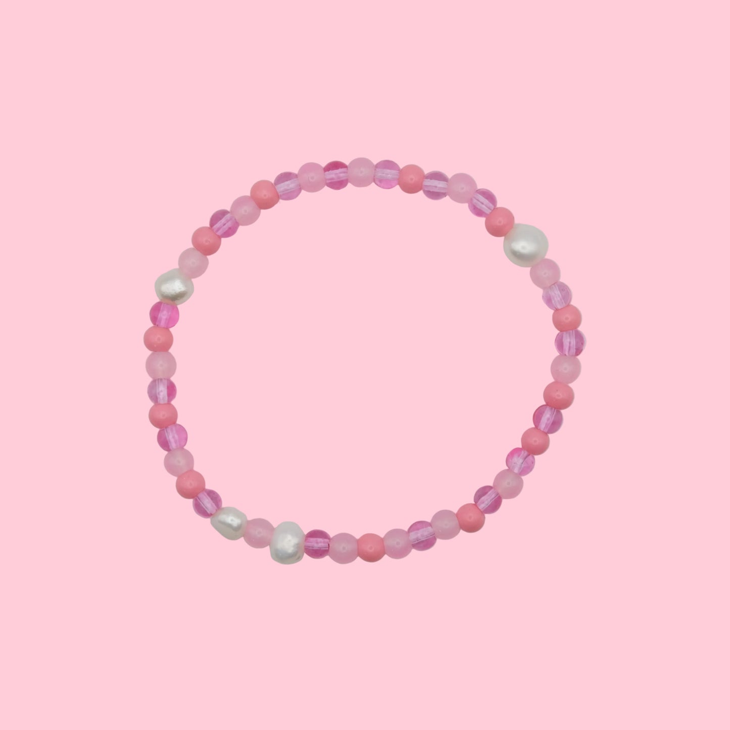 An elastic beaded bracelet composed of 4mm glass beads in pink  tones - featuring small freshwater pearl accents, shown on a white background.