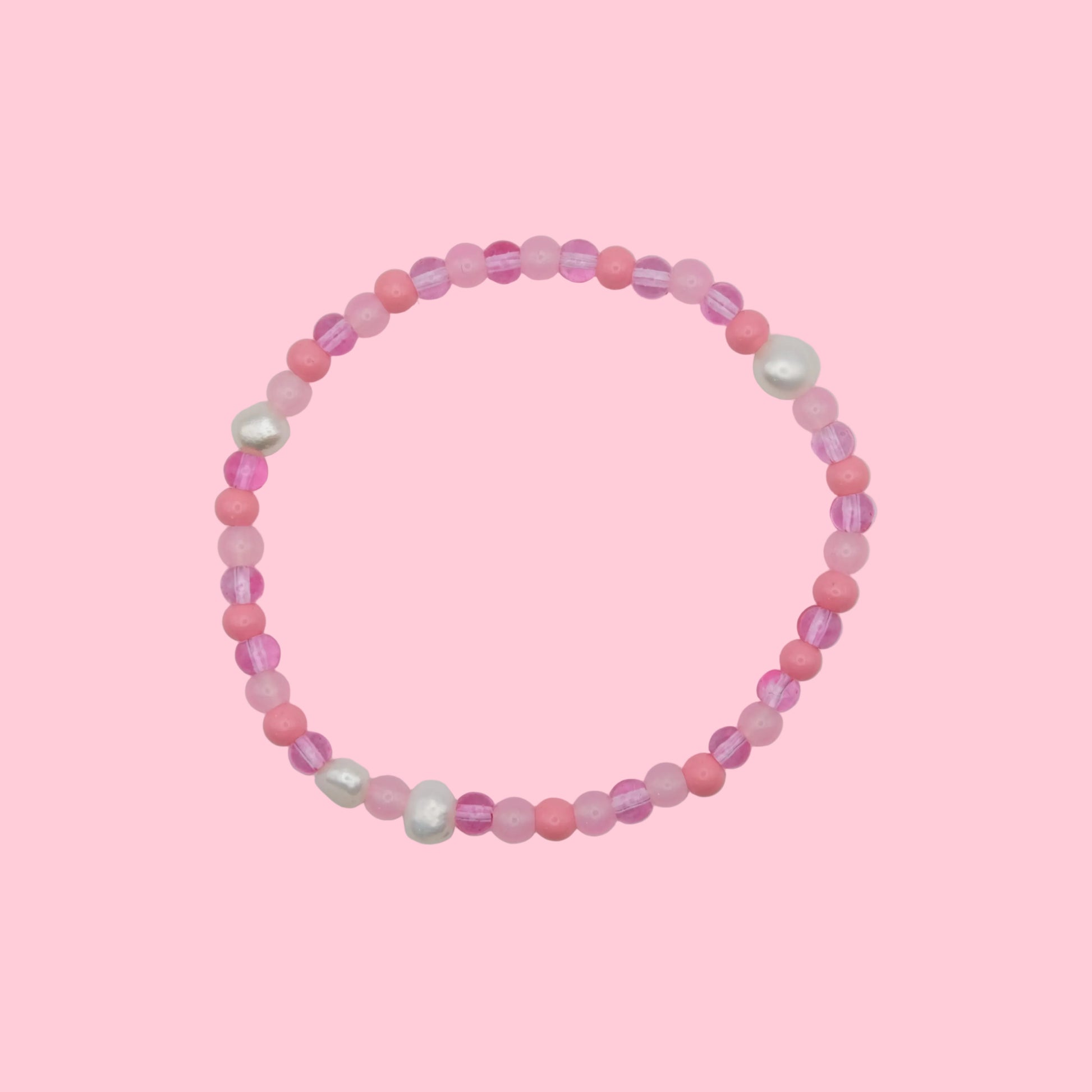 An elastic beaded bracelet composed of 4mm glass beads in pink  tones - featuring small freshwater pearl accents, shown on a white background.
