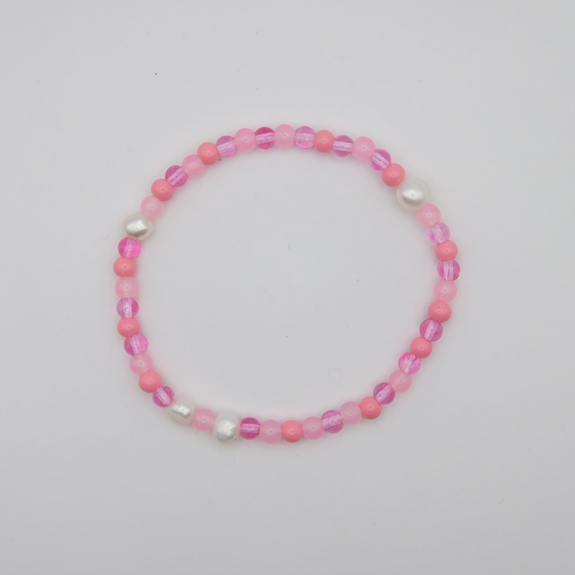 Pink beaded bracelet on a light gray background
