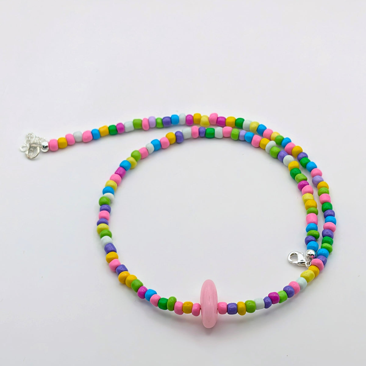 Rachel handmade beaded necklace with colourful pink, blue, green, yellow and purple glass beads and a dyed pink jade feature bead .