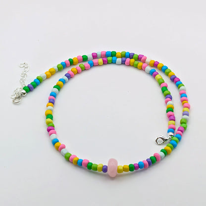 Colourful Rachel beaded necklace featuring rainbow glass beads, a dyed pale pink jade feature bead and silver clasp and extension chain.