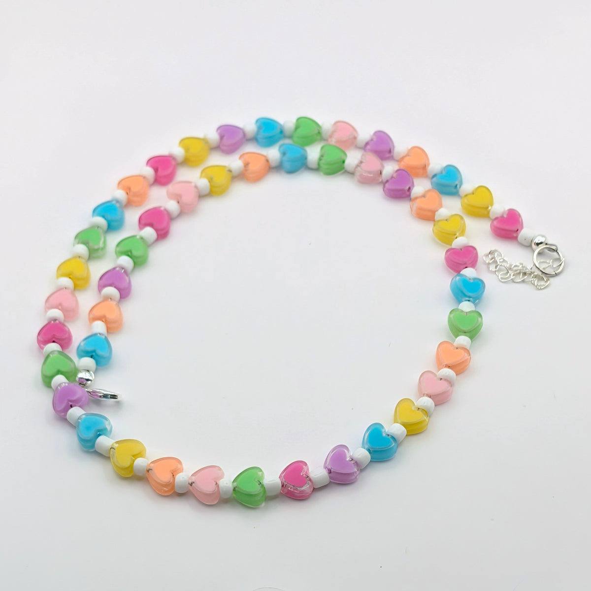 Handmade colourful heart necklace with pink, blue, green, yellow, purple and orange beads, white glass seed beads and silver-plated findings.