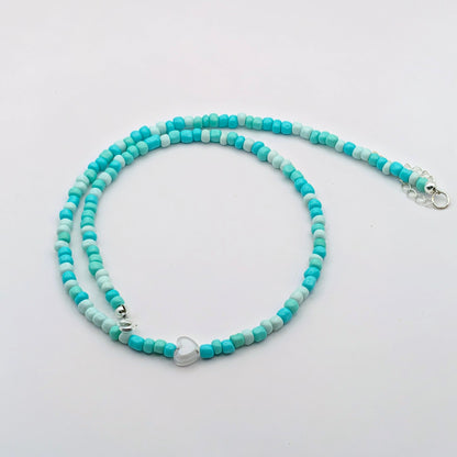 Sara handmade beaded necklace with aqua and pale blue glass beads, translucent heart bead, silver clasp and extension chain.