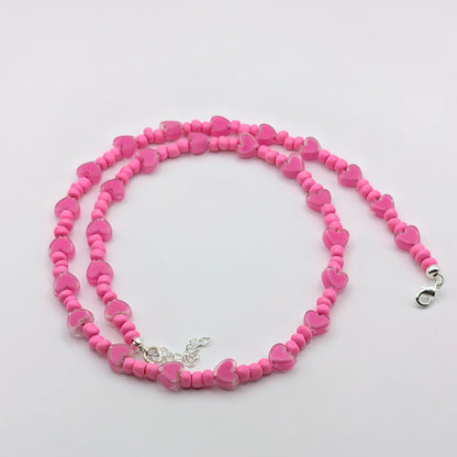 Wendy handmade pink beaded necklace with bright pink glass beads, translucent pink heart beads, silver clasp and adjustable extension chain.