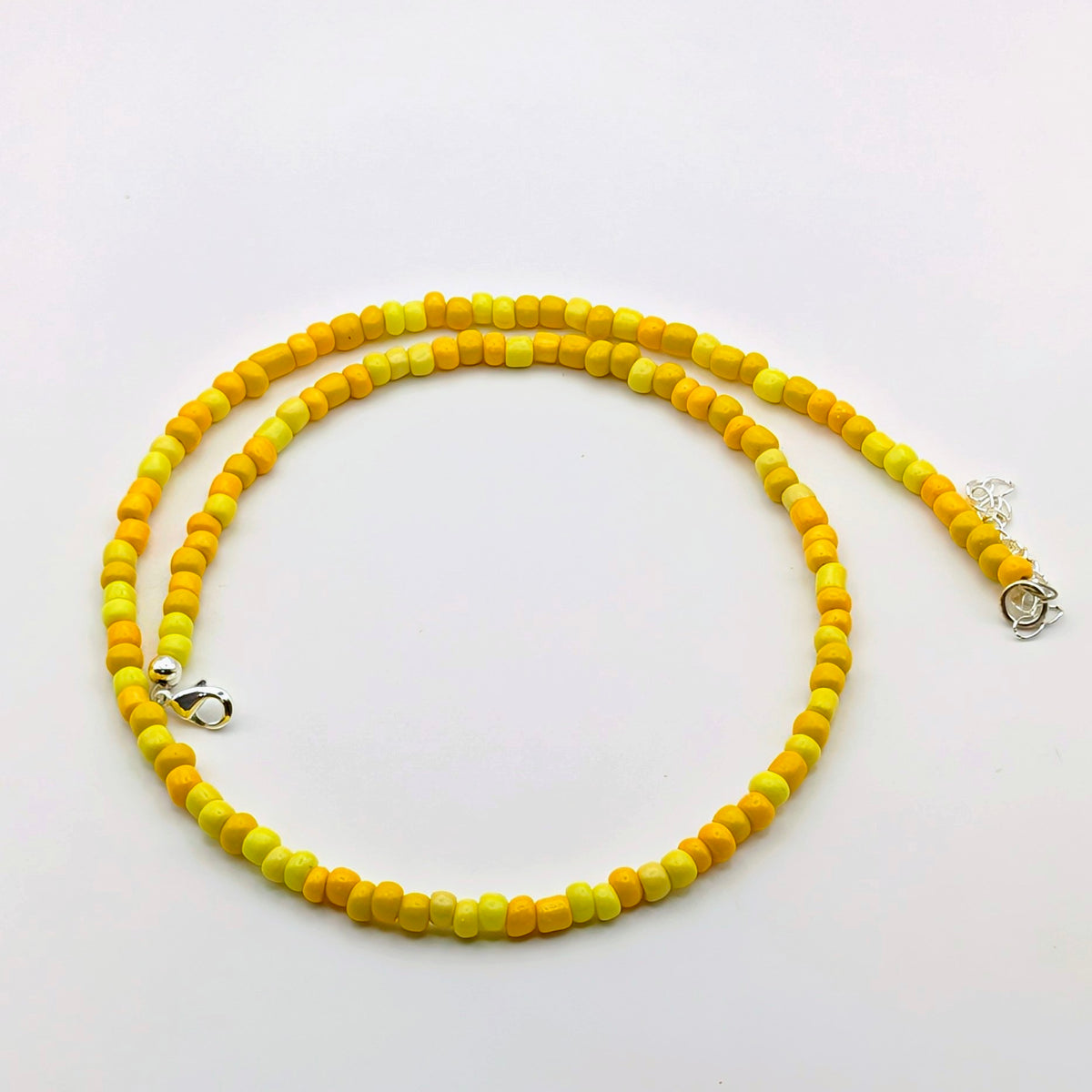 Fran handmade beaded necklace featuring bright yellow and golden yellow glass beads with silver clasp and adjustable extension chain.