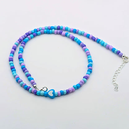 Sara colourful beaded necklace with blue, aqua and purple glass beads, blue and white heart bead and silver adjustable hardware.