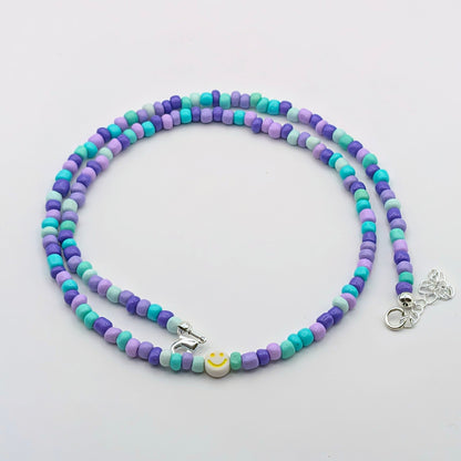 Purple, aqua and mint Phoebe handmade beaded necklace with glass beads and a yellow smiley feature bead.